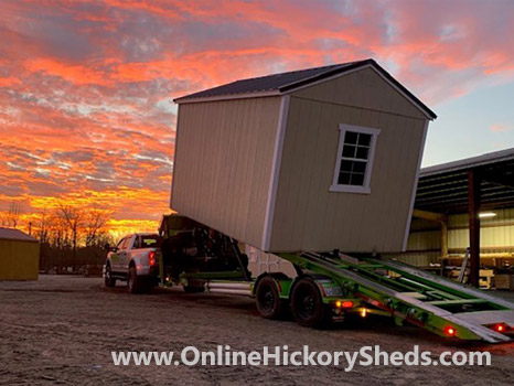Two Hickory Sheds being installed at sunset