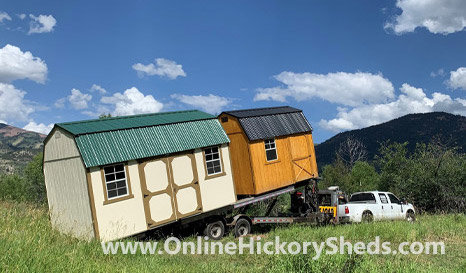 Two Hickory Sheds being towed through a field